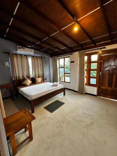 a large room with a bed and a couch at Pineapple Surf Arugambay in Arugam Bay