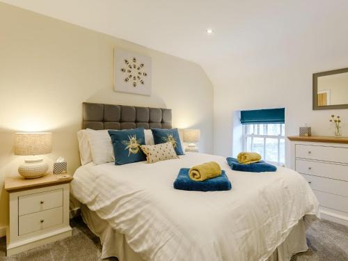 a bedroom with a large bed with blue pillows on it at 2 Bed in Brassington 77632 in Brassington