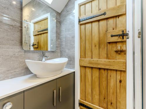 a bathroom with a sink and a wooden door at 2 Bed in Brassington 77632 in Brassington