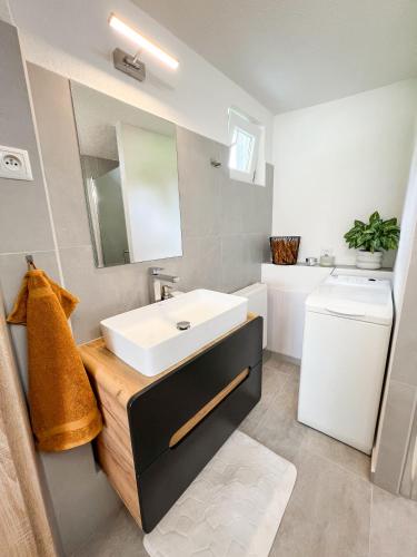 a bathroom with a white sink and a toilet at Nadštandardný apartmán s terasou in Tisovec
