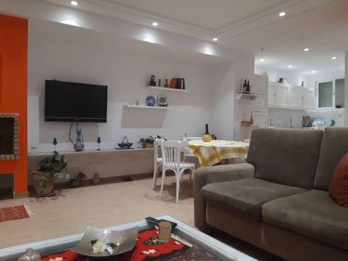 een woonkamer met een bank en een tafel bij Dar Douja / Grandview Waterfront Duplex / Four seasons in Sfax