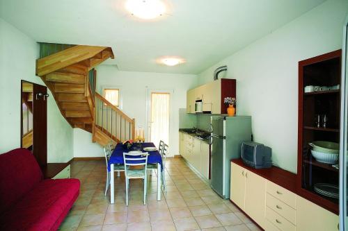 a kitchen with a table and a kitchen with a staircase at Ferienhaus für 10 Personen in Bibione, Adriaküste Italien in Bibione