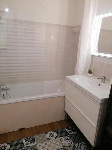 une salle de bain blanche avec une baignoire et un lavabo dans l'établissement T2 centre ville Antigone Piscine Tennis, à Montpellier