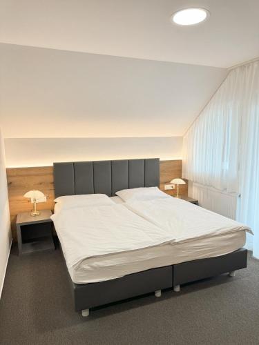 a bedroom with a large bed with white sheets at Hiša Aleš in Kranj