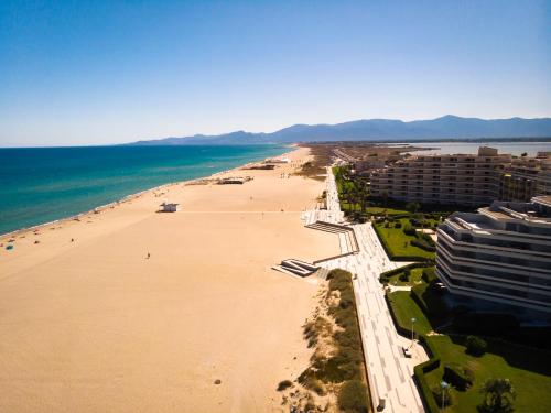 une vue aérienne d'une plage avec des bâtiments et l'océan dans l'établissement Studio cosy en front de mer avec belle vue panoramique sur les montagnes, à Canet