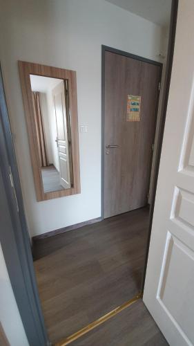 a hallway with a door and a mirror at Logis Hôtel - Les Pasteliers in Lavaur