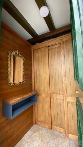 a room with a wooden wall with a mirror and a closet at “La Carpintería” in Prado del Rey