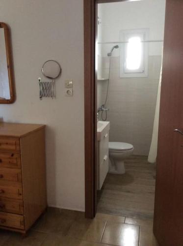 ein Badezimmer mit Toilette, Waschbecken und Fenster in der Unterkunft Vromolithos view in Vromolithos