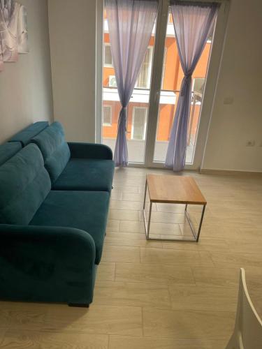 a living room with a blue couch and a coffee table at S3 Apartment 4 in Margjonaj