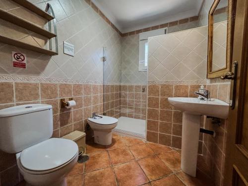 a bathroom with a toilet and a sink at Villa Rosal- Solo familias y parejas in Conil de la Frontera