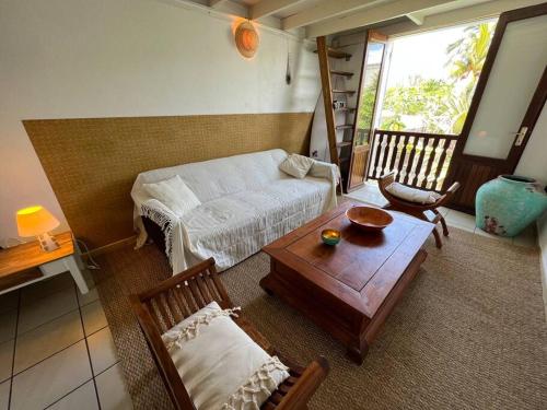 uma sala de estar com uma cama e uma mesa em Les zoizeaux - T2 à 100m de la plage em Saint-Gilles-les-Bains
