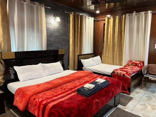 ein Hotelzimmer mit 2 Betten und einem Stuhl in der Unterkunft Gayatri Niwas - Luxury Private room with Ensuit Bathroom - Lake View and Mountain View in Nainital