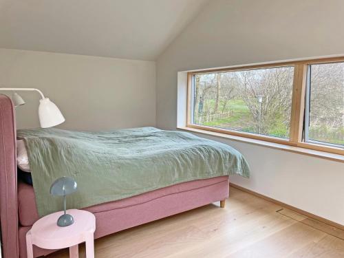 Schlafzimmer mit einem Bett und einem Fenster in der Unterkunft Remise am Fährhaus in Ulsnis