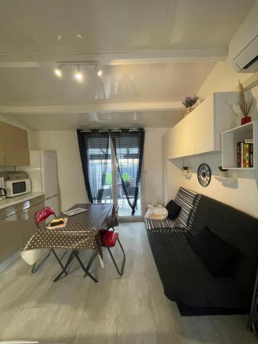 un salon avec un canapé et une table dans l'établissement Appart au cœur des pins - 2 chambres - 6 personnes-clim-parking, au Cap d'Agde