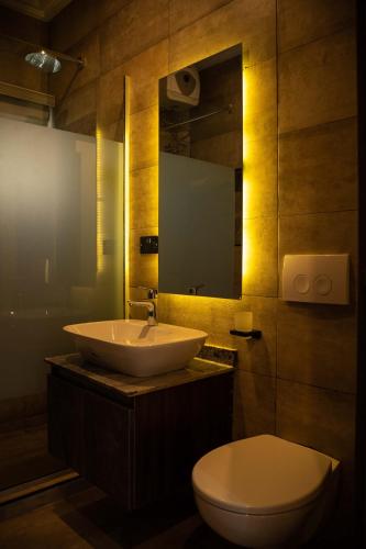 a bathroom with a sink and a toilet and a mirror at Duplex16 in Enugu
