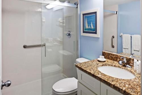 La salle de bains est pourvue de toilettes, d'un lavabo et d'une douche. dans l'établissement Royal Floridian Resort by Spinnaker, à Ormond Beach