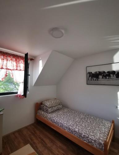 a bedroom with a bed in the corner of a room at Kućica na Jezeru Ovčarsko-kablarska klisura Boat Access Only in Čačak
