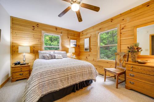 Schlafzimmer mit einem Bett und einem Deckenventilator in der Unterkunft Peaceful Smoky Mountain Cabin with Deck and Fire Pit! in Waynesville