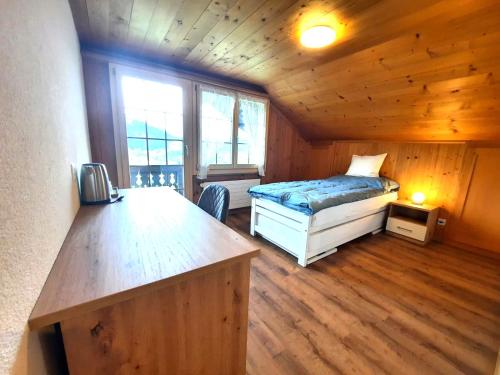 a bedroom with a bed and a desk in a cabin at Gasthof Engelberg in Scharnachtal 