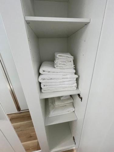 un armario con toallas blancas en un estante en Unique Houseboat Modern and New en Fort Lauderdale