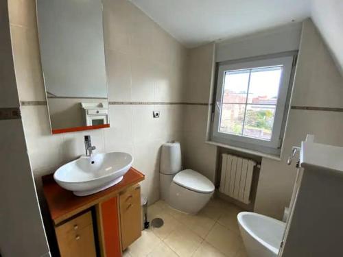 a bathroom with a sink and a toilet and a mirror at Chalet con Piscina Privada in Santander
