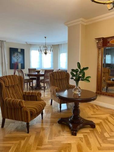 a living room with chairs and a table and a dining room at Chalet con Piscina Privada in Santander