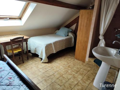um pequeno quarto com uma cama e um lavatório em A L'ETAPE DE LA FERME em Noailles