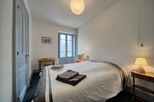 a bedroom with a bed with towels on it at Maison Familiale in Luchon