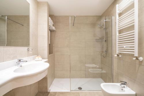 加爾尼亞諾的住宿－Residence Dany appartamenti con cucina vista lago piscina e parcheggio，一间带水槽和淋浴的浴室
