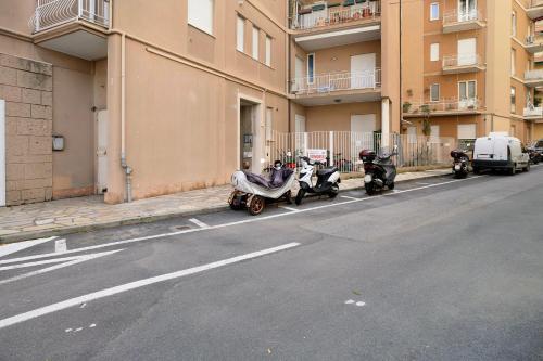 a row of scooters parked on the side of a street at Mirafiori in Alassio