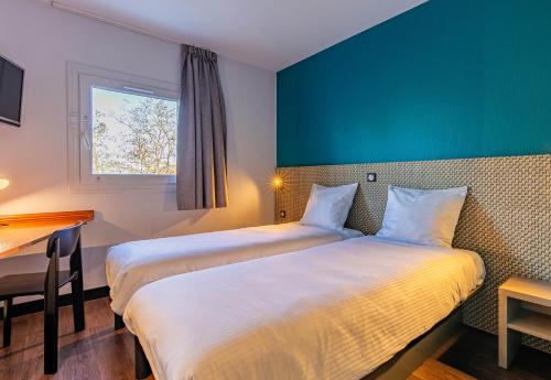 Cette chambre comprend deux lits et un bureau. dans l'établissement B&B HOTEL Colmar Lumière, à Colmar