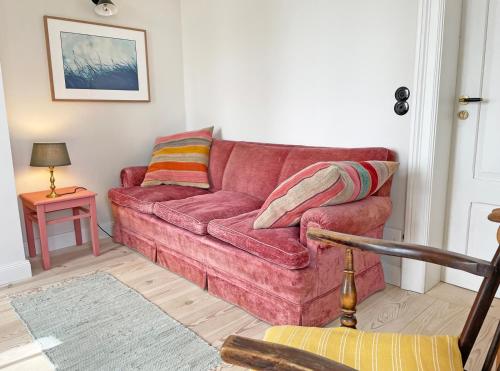 a living room with a red couch and a table at Kleines Fährhaus in Ulsnis