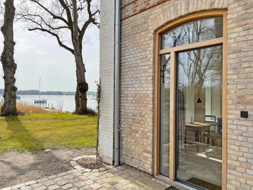 a brick building with a large sliding glass door at Kleines Fährhaus in Ulsnis