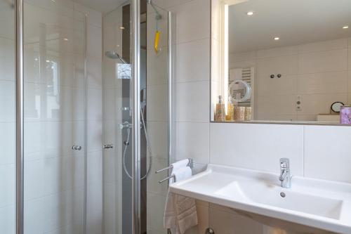 ein Bad mit einem Waschbecken und einer Dusche in der Unterkunft Vik6 10 Viktoria Residenz in Westerland