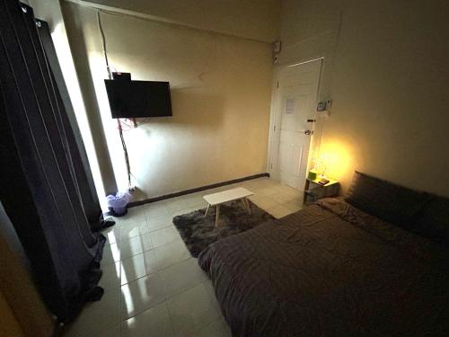 Un dormitorio con una cama y una mesa y una ventana. en P29, en Bangkok