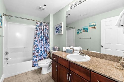 a bathroom with a sink and a toilet and a shower at Laketown Wharf 1817 in Panama City Beach