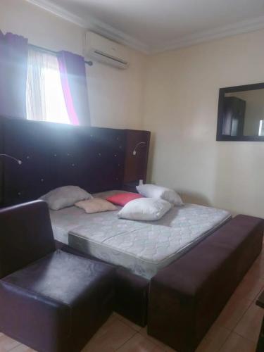 ein Schlafzimmer mit einem Bett und einem Stuhl darin in der Unterkunft House 7 in Lagos