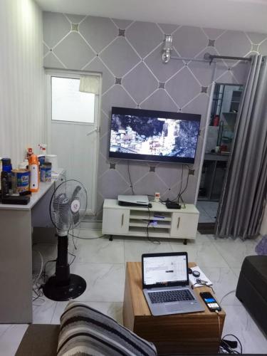 ein Wohnzimmer mit einem Laptop und einem TV in der Unterkunft House 7 in Lagos