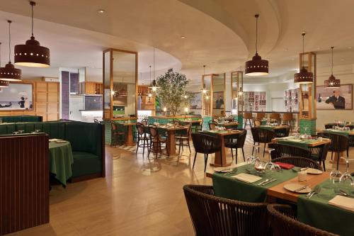 a restaurant with tables and chairs with green table cloth at H10 Playa Esmeralda - Adults Only in Costa Calma
