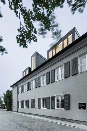 a large white building with black shuttered windows at Lukas Kapeller Hotel und Restaurant in Steyr