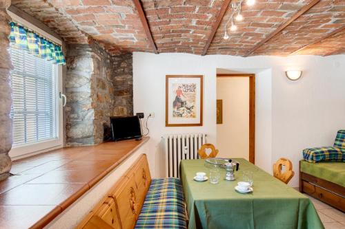 a dining room with a green table and chairs at Maison Jaccod_piano terra in Morgex