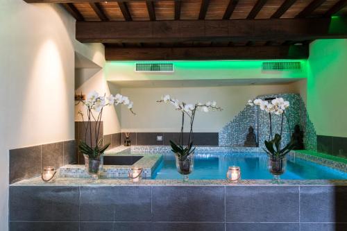 a swimming pool with vases with flowers in it at Relais La Costa Historical Residence in Monteriggioni