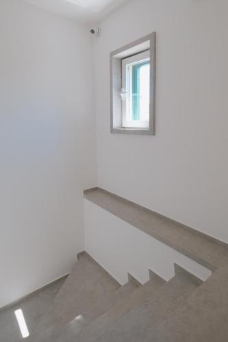 a stair case with a window in a white room at La Finestrella in Bari