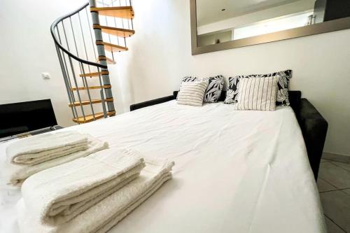 a bedroom with a white bed with towels on it at Terrasse 360° avec vue sur vallée, sans vis à vis in Poussan
