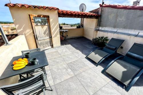 une terrasse avec des chaises et une table avec des fruits. dans l'établissement Terrasse 360° avec vue sur vallée, sans vis à vis, à Poussan