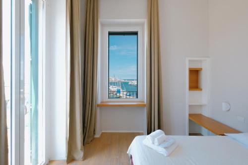 a room with a bed and a large window at La Finestrella in Bari
