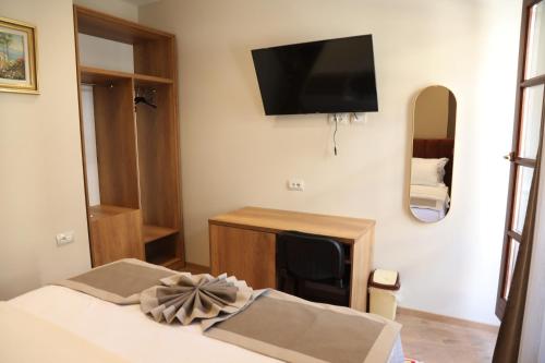 a bedroom with a bed and a tv on the wall at Villa Castriota in Krujë