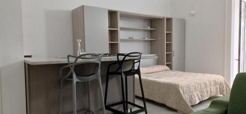a room with a bed and a desk with two chairs at NANNI LOFT HOUSE in Castellammare di Stabia