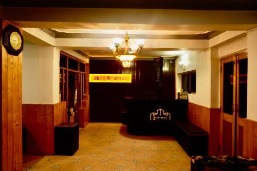 eine Lobby mit einem Schild an der Wand und einer Uhr in der Unterkunft Hotel Leh Castle in Leh