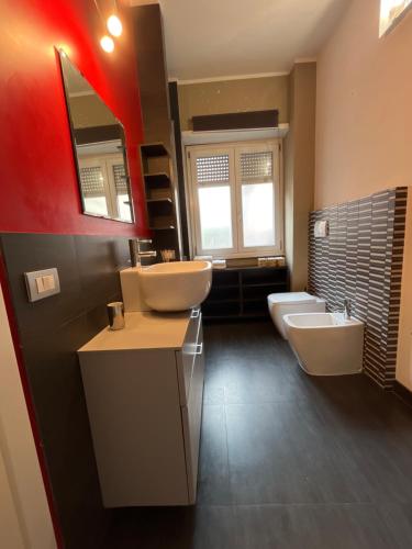 La salle de bains est pourvue de 2 lavabos, de toilettes et d'un miroir. dans l'établissement Appio 155 Apartment, à Rome